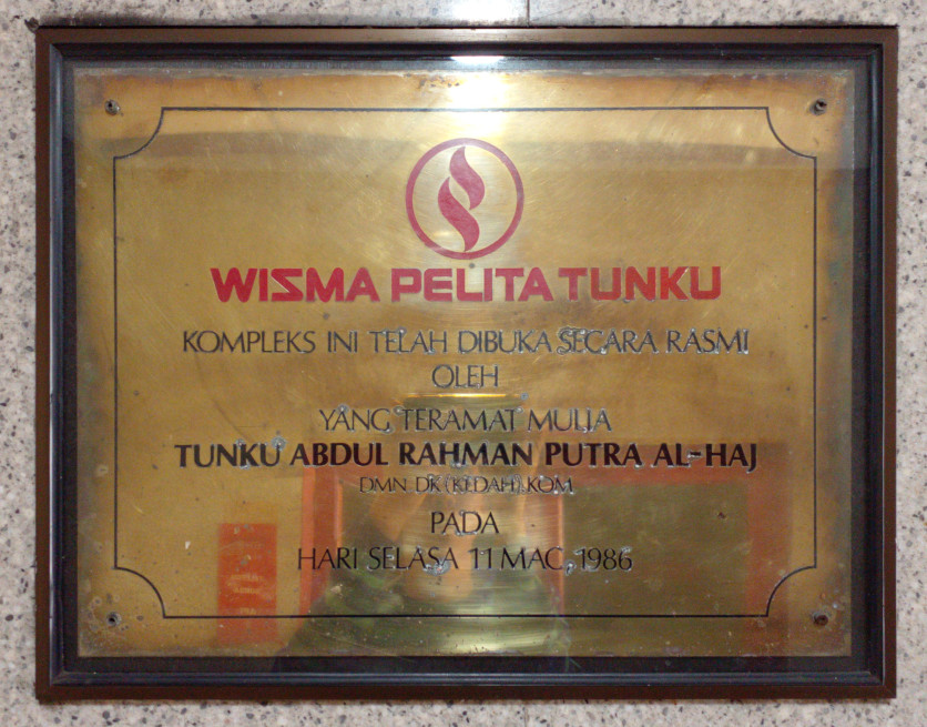 A plaque: "WISMA PELITA TUNKU - KOMPLEKS INI DIBUKA SECARA RASMI OLEH: YANG TERAMAT MULIA: TUNKU ABDUL RAHMAN PUTRA AL-HAJ, DMN DK (KEDAH). KOM, PADA HARI SELASA 11 MAC, 1986"